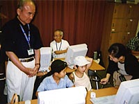 シニアの講師と子供達にインタビューする山口キャスター