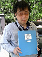 完成した点字版の「世田谷区災害時区民行動マニュアル」と大竹さん(防災フェアの会場で)